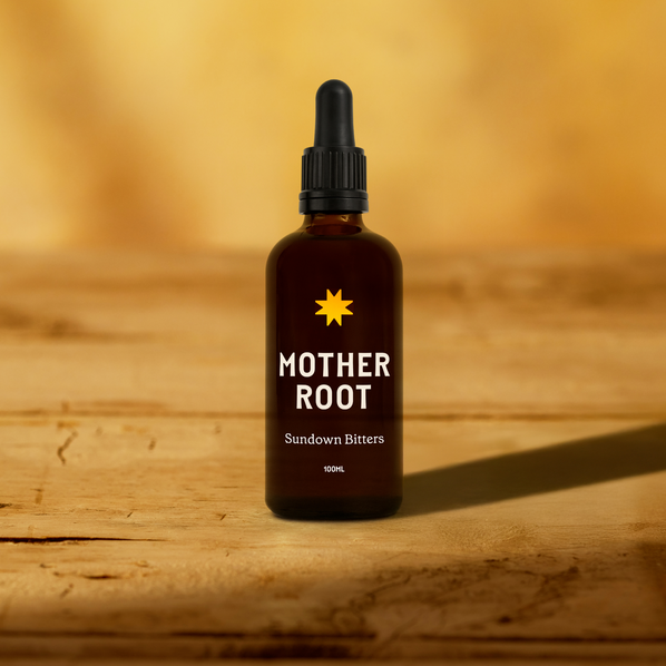 Bottle of 'Mother Root' Sundown Bitters on a wooden surface with a warm background